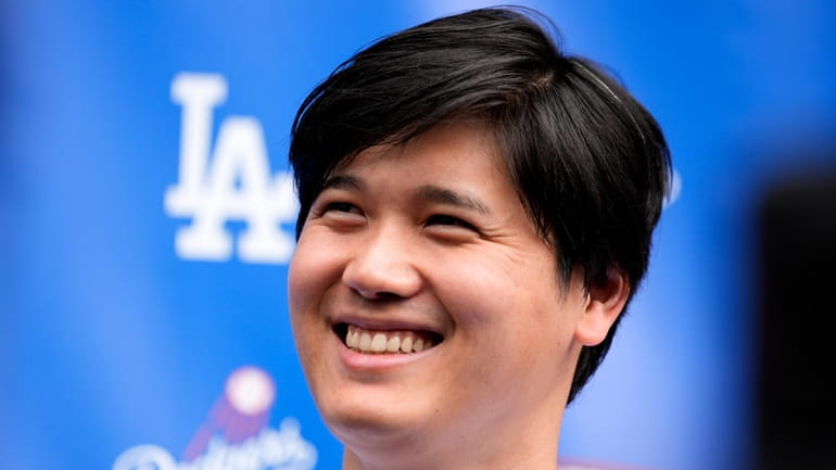 Los Angeles Dodgers' Shohei Ohtani smiles while talking to the...