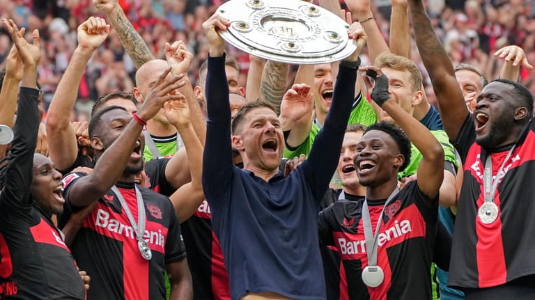 Leverkusen's head coach Xabi Alonso celebrates with the trophy as...