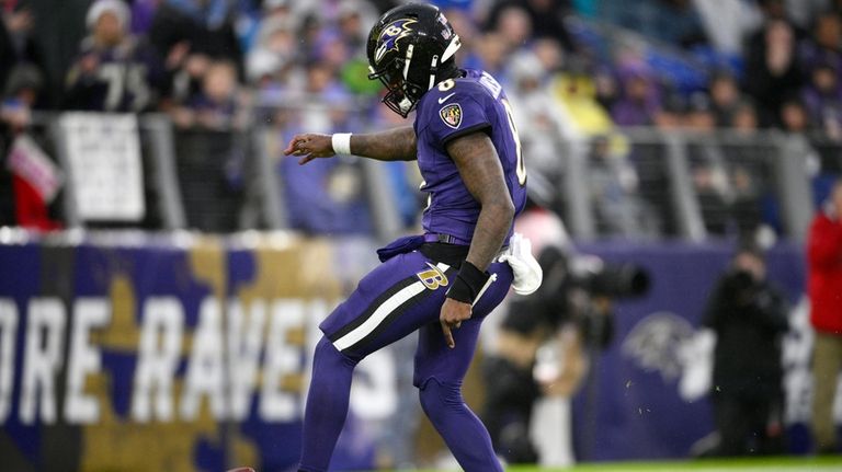 Baltimore Ravens quarterback Lamar Jackson kicks the ball out of...