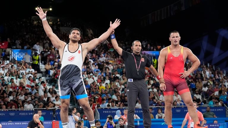 Turkey's Taha Akgul celebrates after defeating Kyrgyzstan's Aiaal Lazarev in...