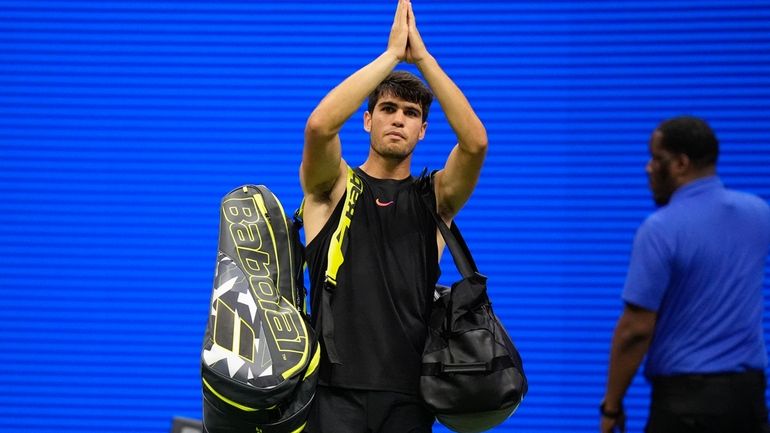 Carlos Alcaraz, of Spain, gestures to fans after losing to...