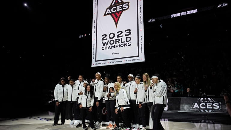 Las Vegas Aces players pose as they raise the 2023...