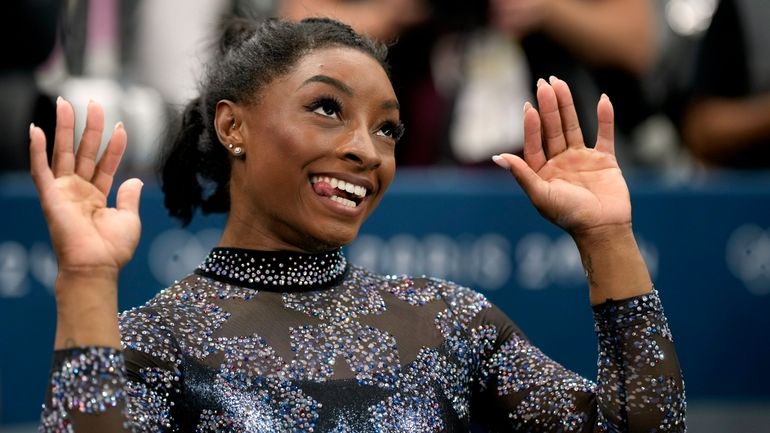 Simone Biles, of United States, celebrates after competing on the...