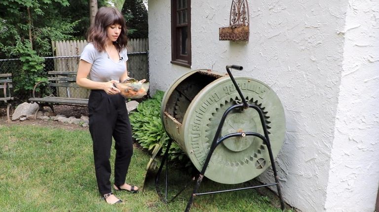 Nicole Lentini throws food and vegetable scraps into their compost...