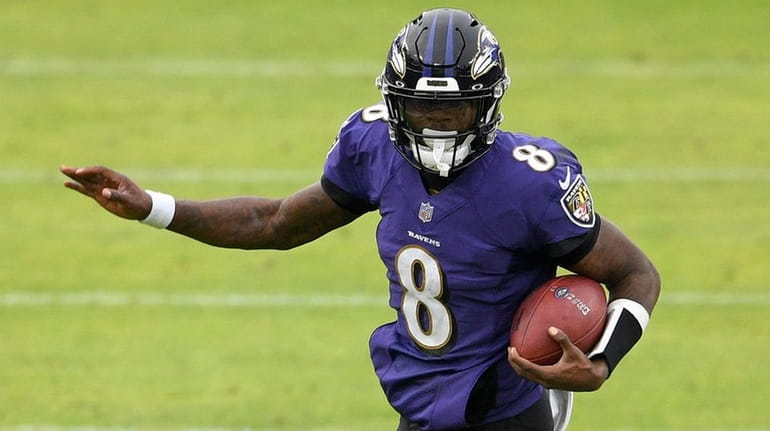 Ravens quarterback Lamar Jackson avoids a sack attempt by Jaguars safety Josh...