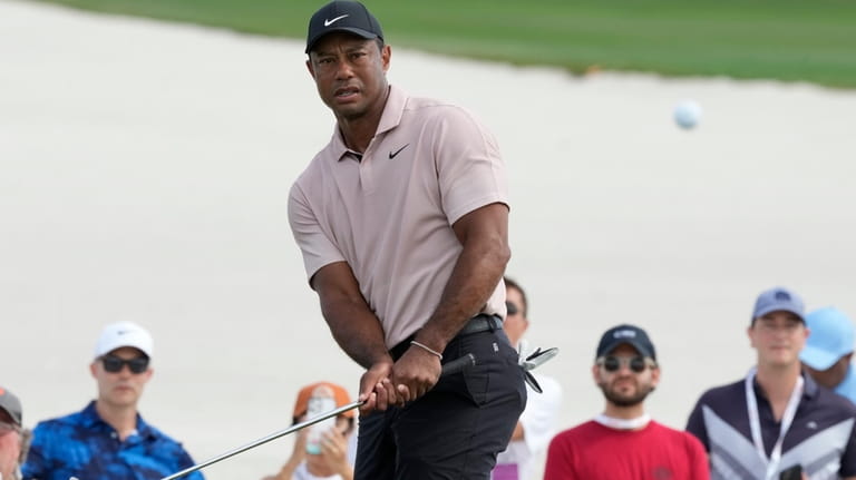 Tiger Woods watches his shot at the third green during...