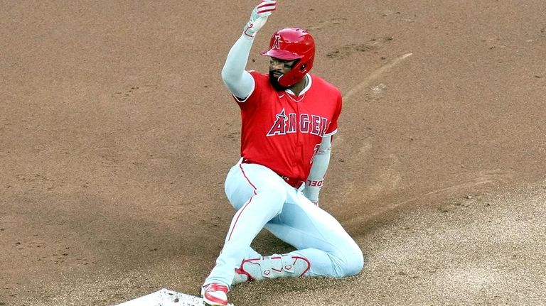 Los Angeles Angels ' Jo Adell slides into second base...