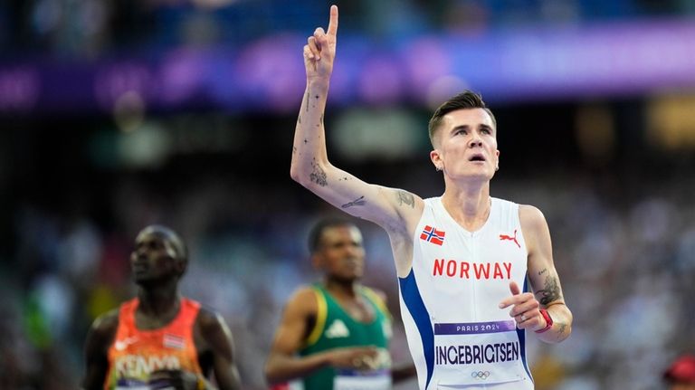 Jakob Ingebrigtsen, of Norway, celebrates after winning the men's 5000-meter...