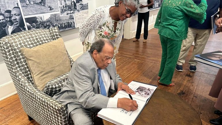 Civil rights icon Andrew Young signs a book for Sonjia...