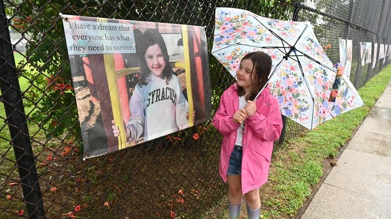 Lucy Cain stands beside her portrait outside of Plaza Elementary...