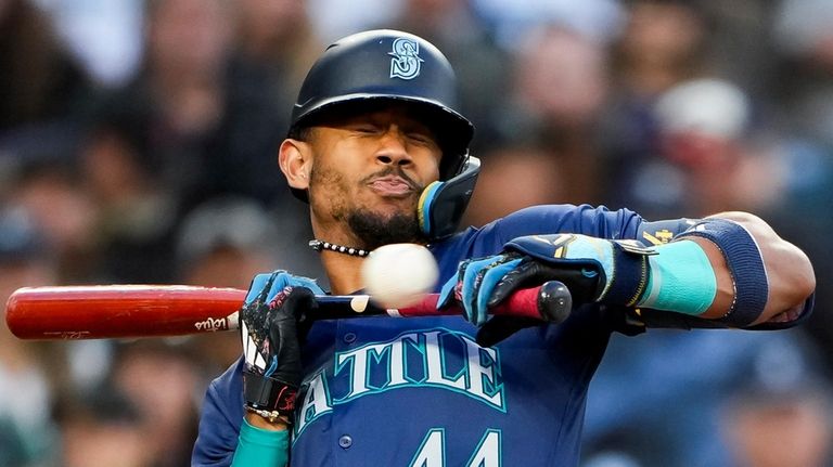 Seattle Mariners' Julio Rodríguez winces at a close ball after...