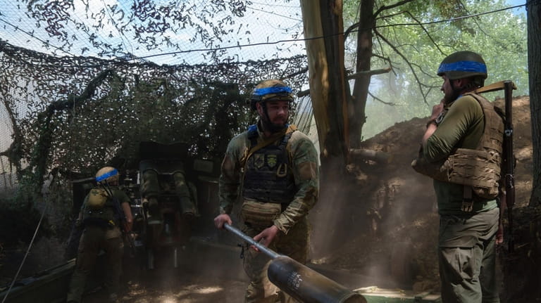 Ukrainian national guard servicemen of Khartia brigade reload a D-20...