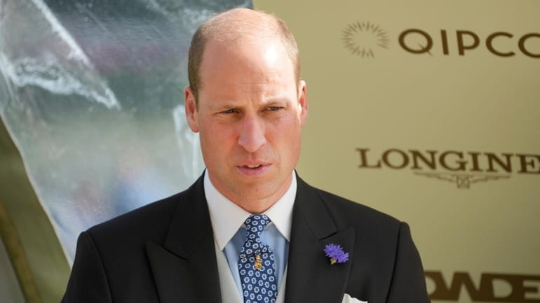 Britain's Prince William prepares to present the winning owners, trainer...