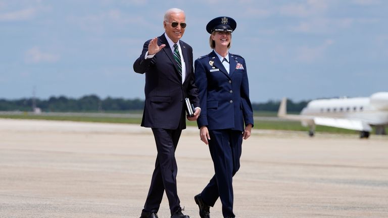 President Joe Biden, escorted by Air Force Col. Angela Ochoa,...