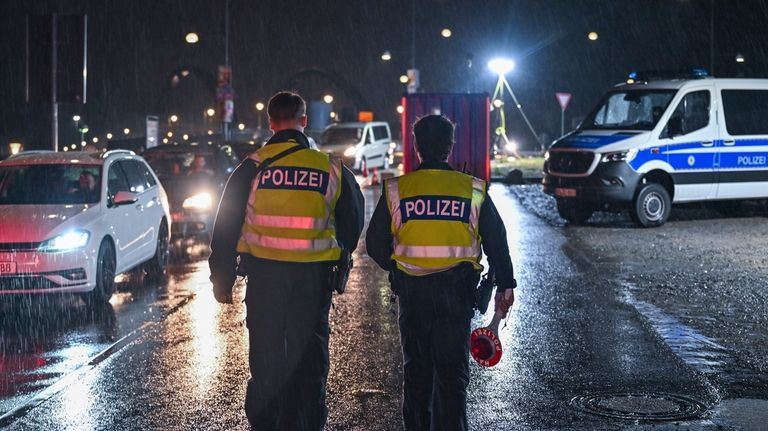 Two German Federal Police officers patrol at the border crossing...