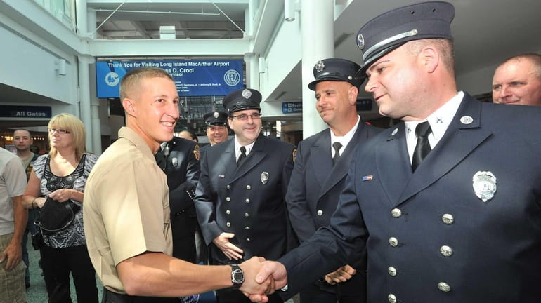 U.S. Navy Corpsman Devin Hudson receives a warm welcome from...