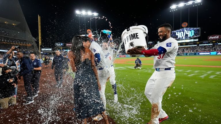 Los Angeles Dodgers' Teoscar Hernández (37) dumps water on designated...