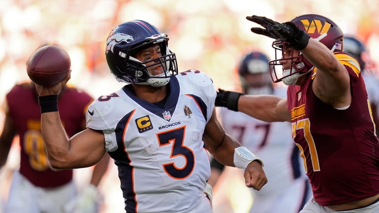 Denver Broncos quarterback Russell Wilson (3) tries to get a...