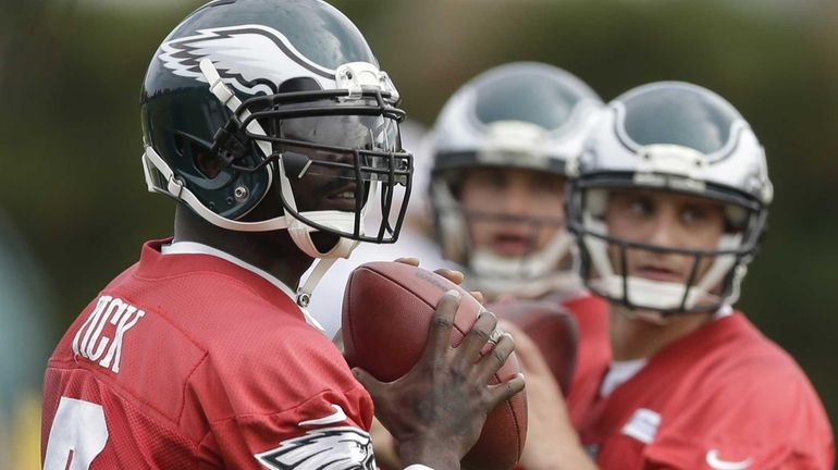 Philadelphia Eagles quarterback Michael Vick, left, G. J. Kinne, right,...