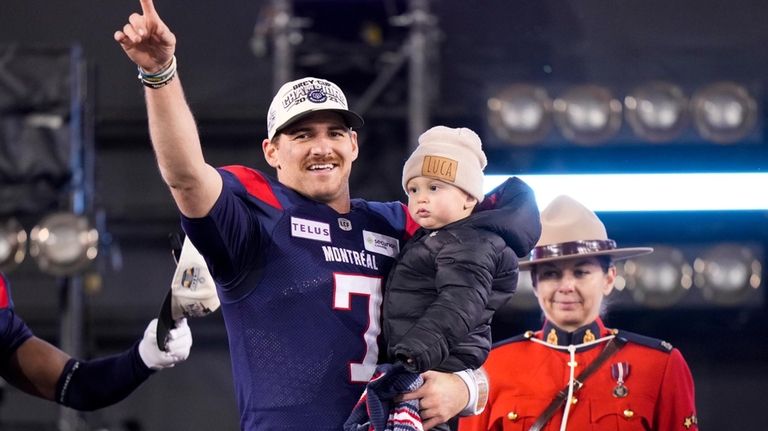 Montreal Alouettes quarterback Cody Fajardo (7) holds his son Luca...