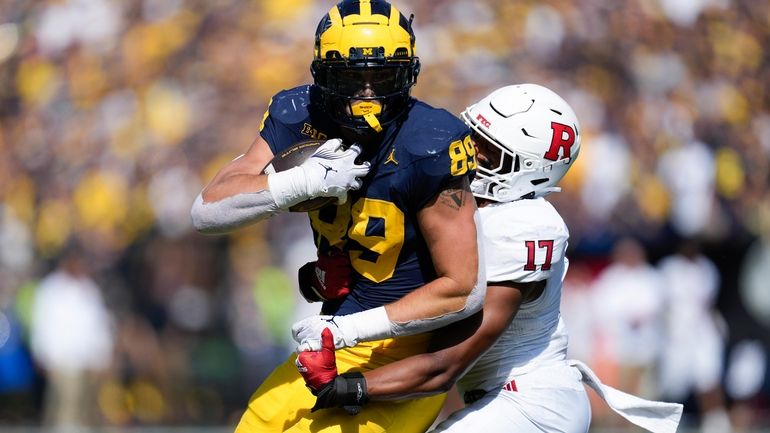 Michigan tight end AJ Barner (89) fights to break the...