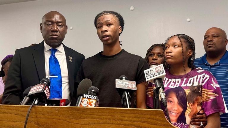 Malachi Hill Massey, 17, center, speaks at a news conference...