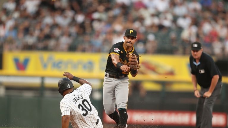 Pittsburgh Pirates' Nick Gonzales, center, throws to first base for...