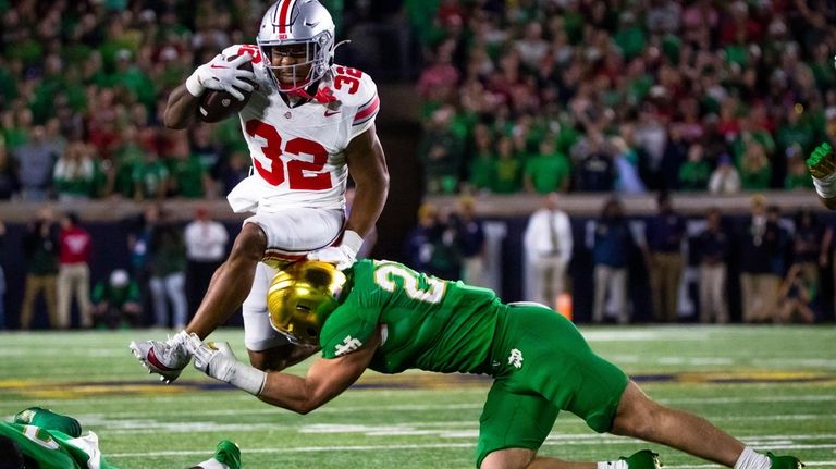 Ohio State running back TreVeyon Henderson (32) tries to jump...