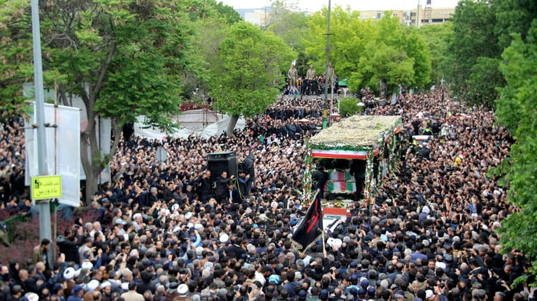 In this photo provided by Fars News Agency, mourners gather...