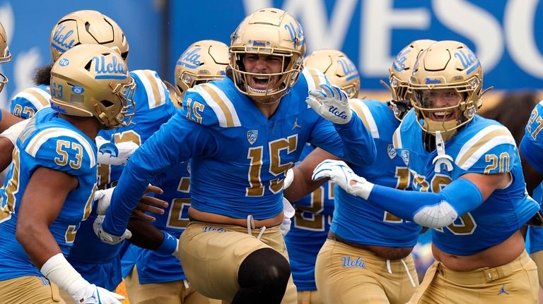 UCLA defensive lineman Laiatu Latu, center, celebrates with teammates after...