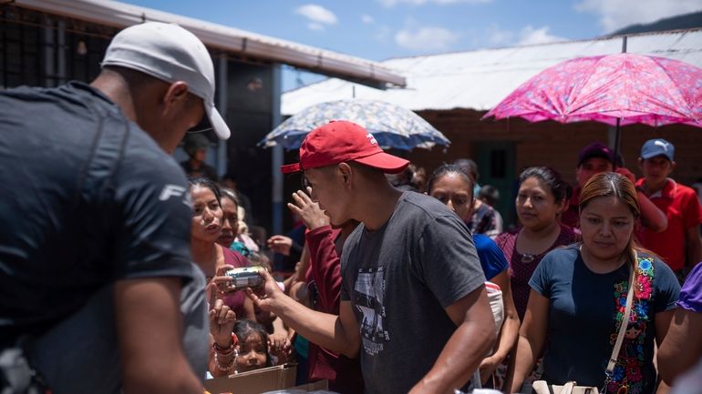 Locals in Guatemala offer sodas to Mexicans who fled their...