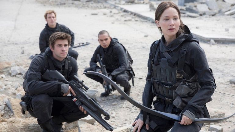 Liam Hemsworth, left, as Gale Hawthorne, Sam Clafin, back left,...