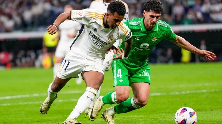 Real Madrid's Rodrygo, left, fights for the ball with Betis'...