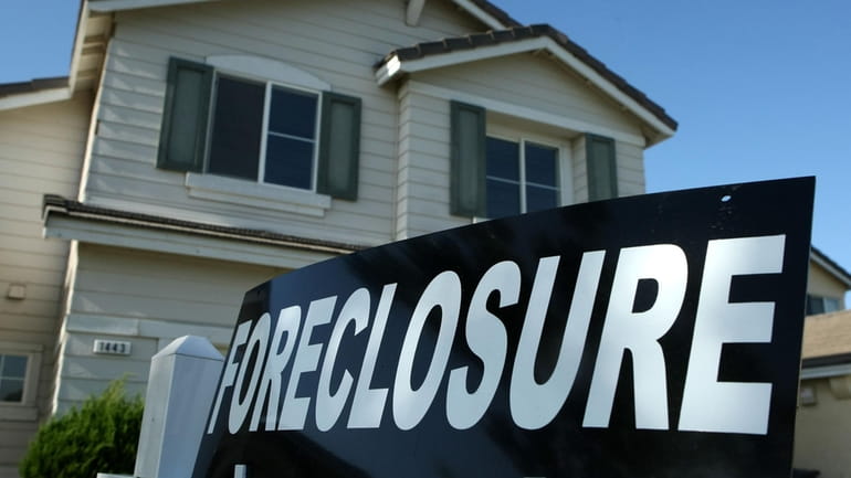A foreclosure sign is posted in front of a home...