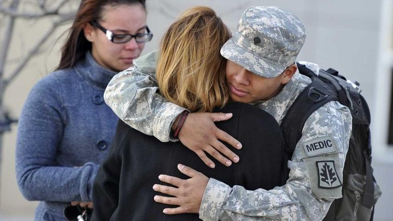 Specialist Orli Benitez of West New York, NJ, hugs his...