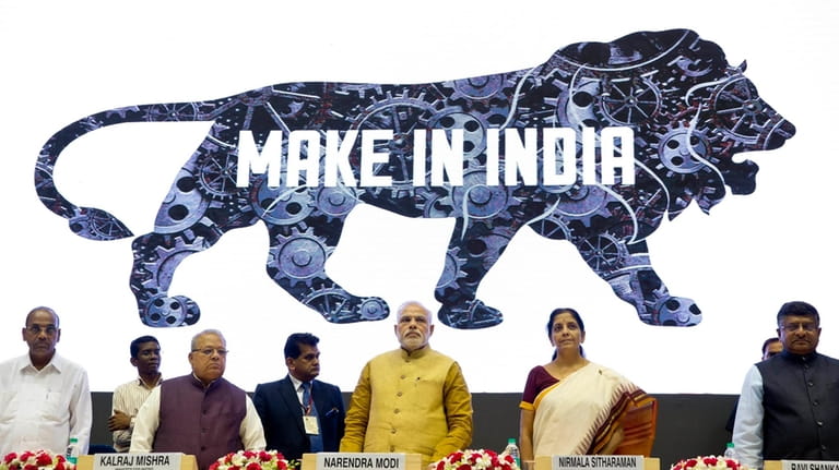 Indian Prime Minister Narendra Modi, center, unveils the logo of...