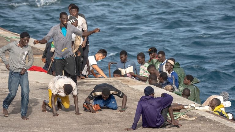 Unauthorized migrants react as they arrive at the port in...