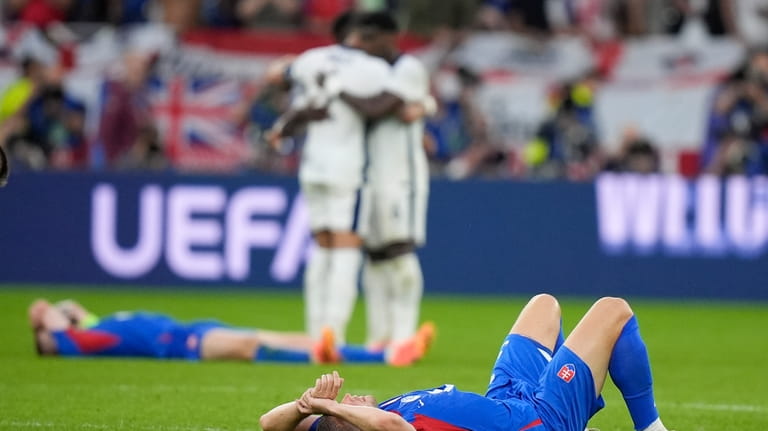 Slovakia players lie on the pitch after a round of...