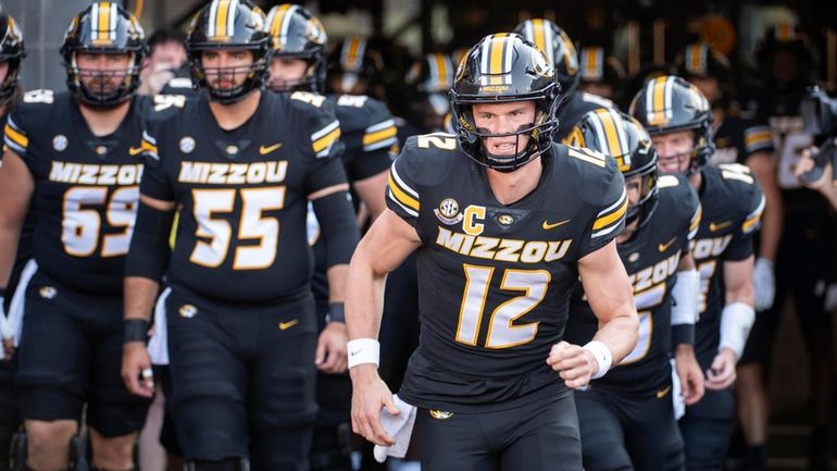 Missouri quarterback Brady Cook (12) leads his team to the...