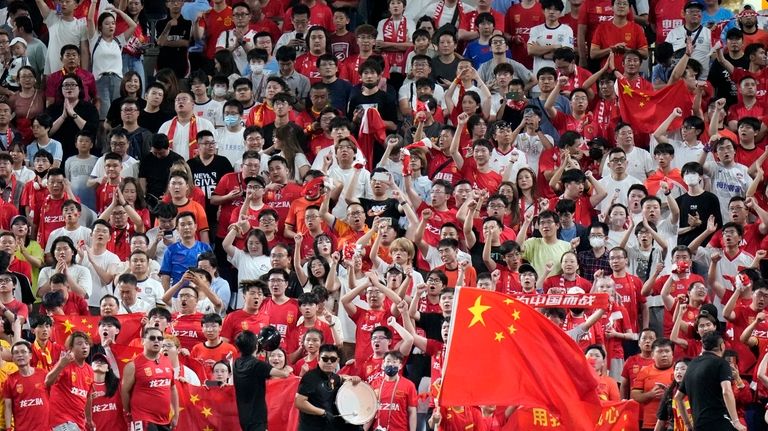 Supporters for Chinese team cheer during a World Cup and...