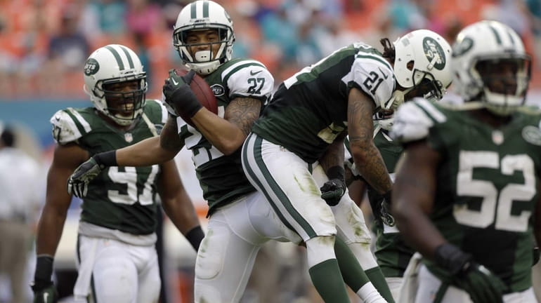 Dee Milliner (27) celebrates with teammates after intercepting a pass...