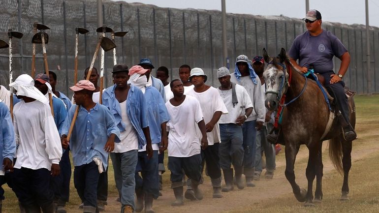 In this Aug. 18, 2011 photo, prison guards ride horses...