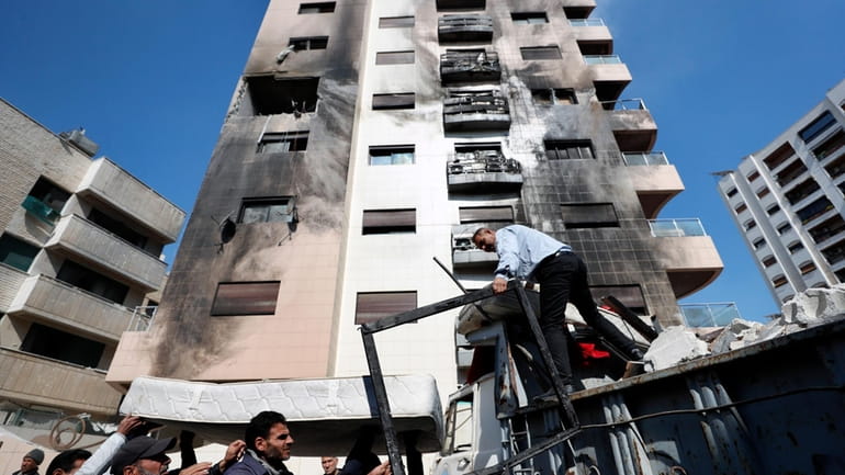 People clean debris after a reported Israeli attack on Syria,...