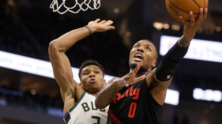 Portland Trail Blazers' Damian Lillard (0) drives against Milwaukee Bucks'...