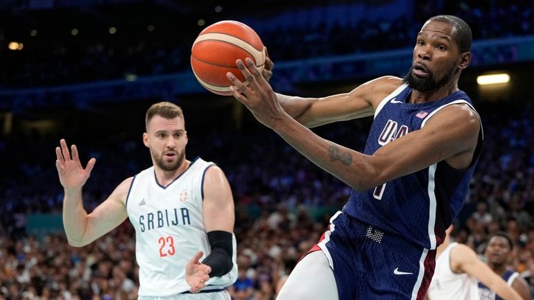 Kevin Durant, right, of the United States, passes the ball...