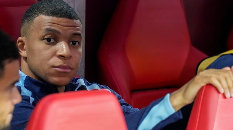 Kylian Mbappe of France looks out from the bench before...