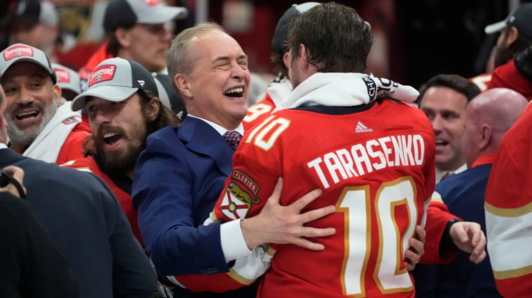 Florida Panthers head coach Paul Maurice, center left, hugs right...