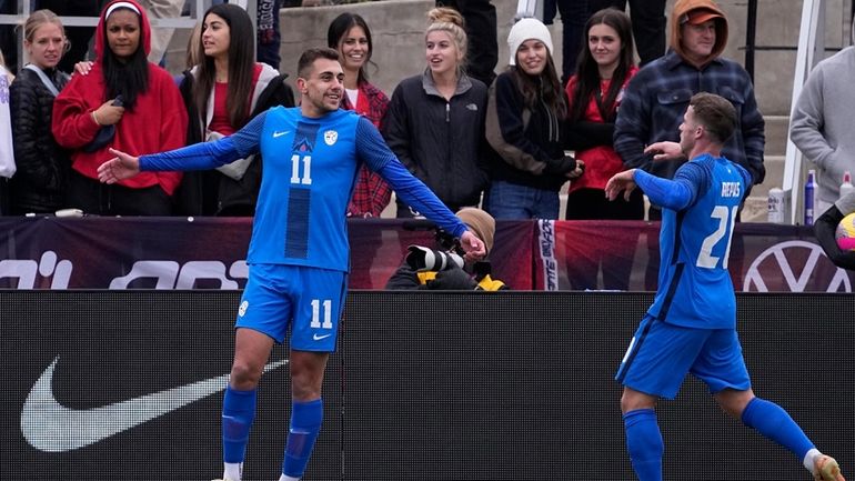 Slovenia forward Nejc Gradisar (11) celebrates his goal with teammate...