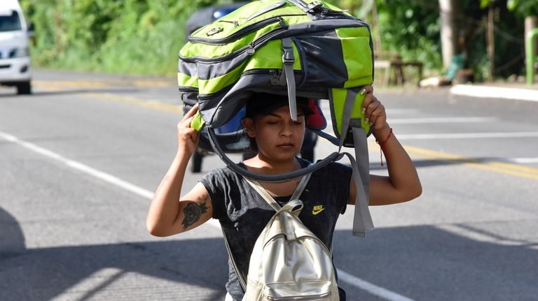 A migrant walks along the highway through Suchiate, Chiapas state...