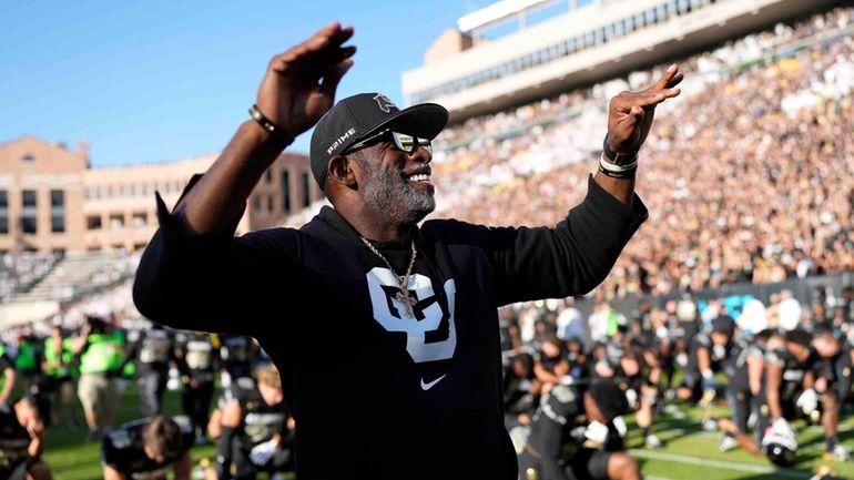 Colorado head coach Deion Sanders conducts fans before an NCAA...